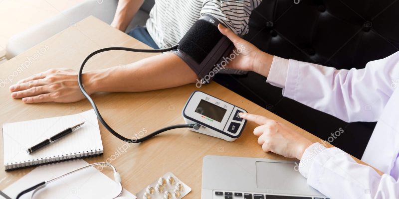 healthcare, hospital and medicine concept – doctor and patient m healthcare, hospital and medicine concept - doctor and patient measuring blood pressure by machine.